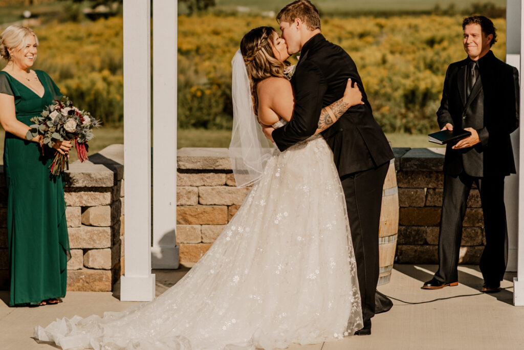 wide photo of bride and grooms first kiss 